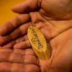 Hände mit Holzschild